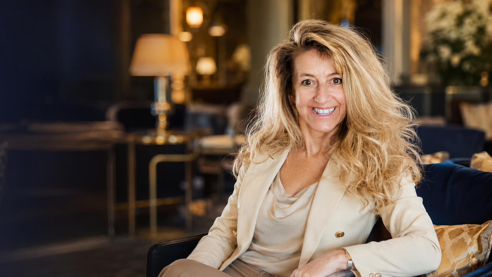 Carmen Cornelia Haselwanter sitzend in einer eleganten Hotel-Lobby, lächelnd in die Kamera
